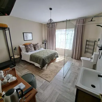 a bedroom with a bed and a glass shower at Diamantvallei Landgoed in Rayton