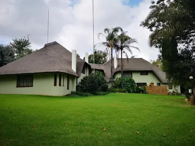 a house with a thatched roof and a yard at Diamantvallei Landgoed in Rayton