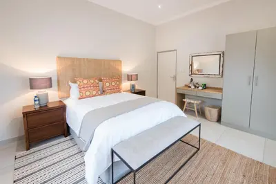 a bedroom with a large bed and a desk at Bushwillow Private Villa in Hoedspruit