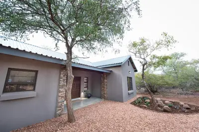 a house with a tree in front of it at Bushwillow Private Villa in Hoedspruit