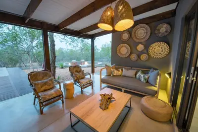 a living room with a couch and chairs and a table at Bushwillow Private Villa in Hoedspruit