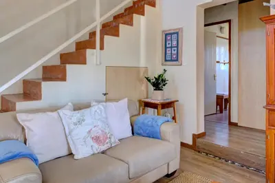 a living room with a couch and stairs at Mrs Simpson in Dullstroom