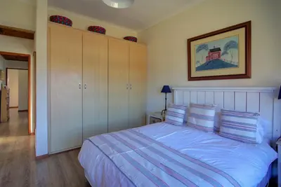 a bedroom with a large bed with blue sheets and pillows at Mrs Simpson in Dullstroom