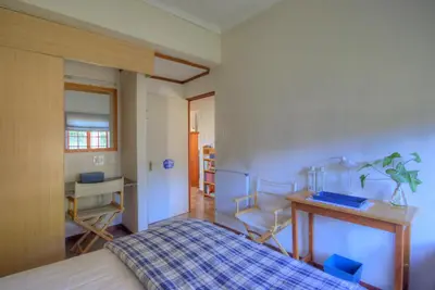 a bedroom with a bed and a table and chairs at Mrs Simpson in Dullstroom
