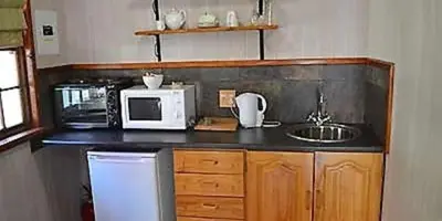 a kitchen with a sink and a microwave at The Pennefather in Haenertsburg