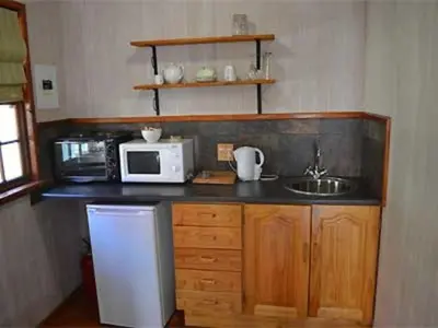 a small kitchen with a sink and a microwave at The Pennefather in Haenertsburg