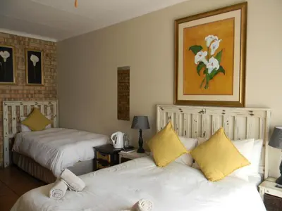 a bedroom with two beds and a picture on the wall at Ridderspoor Guesthouse in Middelburg