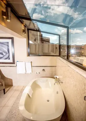 a large bathroom with a tub and a large window at Southern Sun Pretoria in Pretoria