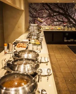 a buffet line with pots and pans of food at Southern Sun Pretoria in Pretoria
