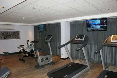 a gym with treadmills and exercise bikes in a room at Southern Sun Pretoria in Pretoria
