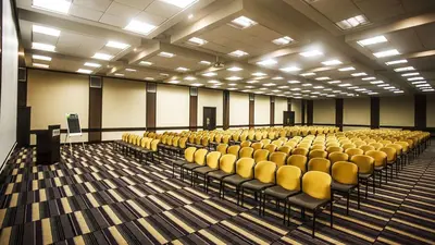 an empty lecture hall with yellow chairs in it at Southern Sun Pretoria in Pretoria