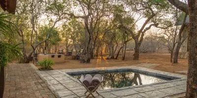 a pair of shoes sitting next to a swimming pool at Warthogs Rest in Hoedspruit