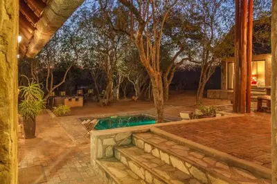 a backyard with a swimming pool and a house at Warthogs Rest in Hoedspruit