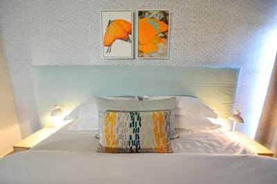 a bedroom with a white bed with three pictures on the wall at Serurubele Boutique Hotel in Bushbuckridge