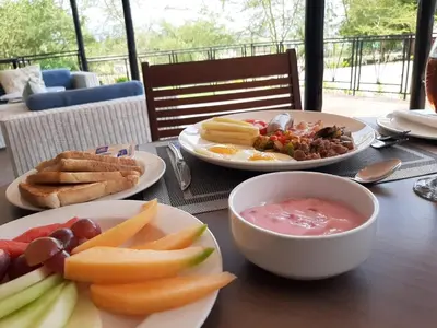 a table with plates of food and a bowl of soup at Serurubele Boutique Hotel in Bushbuckridge