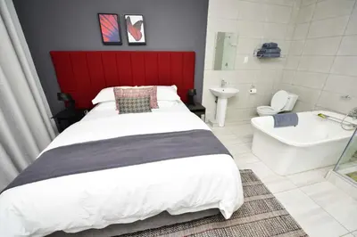 a bedroom with a bed and a tub and a sink at Serurubele Boutique Hotel in Bushbuckridge
