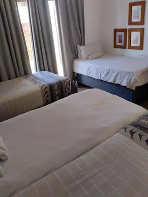 a room with two beds and a window at Woodpecker Guesthouse Middelburg Mpumalanga in Middelburg