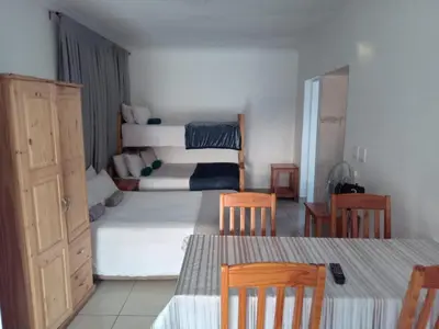 a bedroom with a bed and a table and chairs at Woodpecker Guesthouse Middelburg Mpumalanga in Middelburg