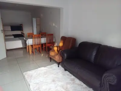 a living room with a black couch and a dining room at Woodpecker Guesthouse Middelburg Mpumalanga in Middelburg