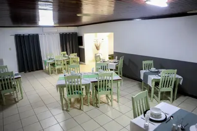 a dining room with green tables and chairs at Gracious Lodge in Burgersfort