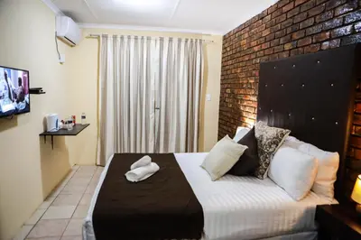 a bedroom with a bed with two towels on it at Gracious Lodge in Burgersfort