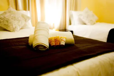 a hotel room with two beds with towels on the bed at Gracious Lodge in Burgersfort