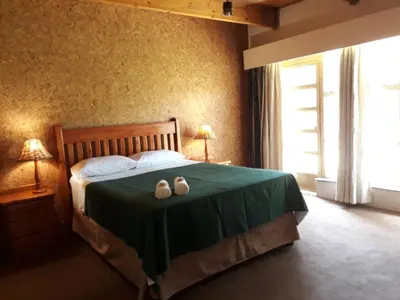 a bedroom with a bed with two shoes on it at Die Plasie on-suite rooms in Hartbeespoort