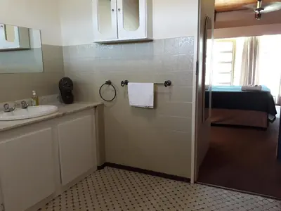 a bathroom with a sink and a shower at Die Plasie on-suite rooms in Hartbeespoort