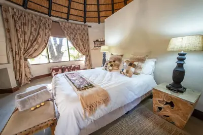 a bedroom with a large bed and a window at Malilule Safaris in Hoedspruit