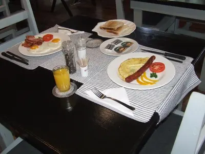 a table with plates of breakfast food on it at Kruger's Guest House in White River