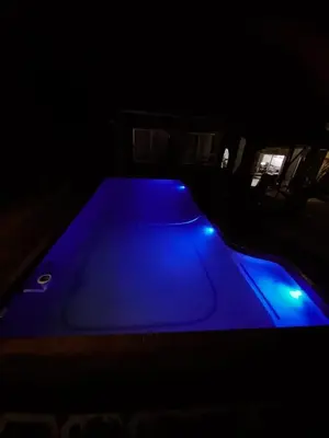 a pool table with blue lights in a dark room at Kruger's Guest House in White River