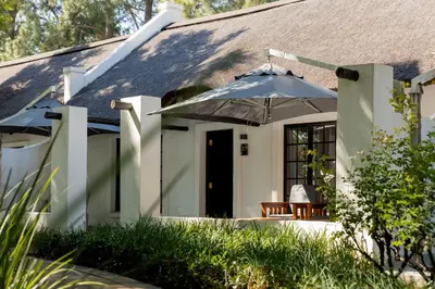 a house with an umbrella over a patio at Kievits Kroon Gauteng Wine Estate in Pretoria