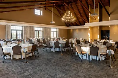 a banquet hall with tables and chairs and a chandelier at Kievits Kroon Gauteng Wine Estate in Pretoria