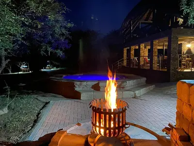 a fire hydrant with flames in a yard at night at Rhinos Rest in Marloth Park