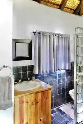 a bathroom with a sink and a mirror at Rhinos Rest in Marloth Park