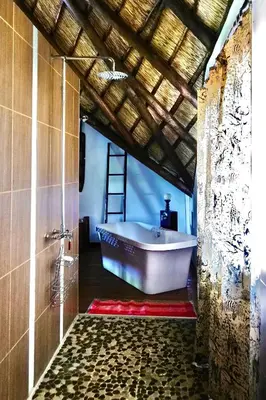 a bathroom with a bath tub in a room at Rhinos Rest in Marloth Park
