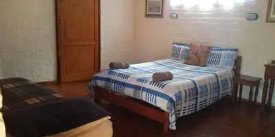 a bedroom with a bed with blue and white sheets at Old Transvaal Inn Accommodation in Dullstroom