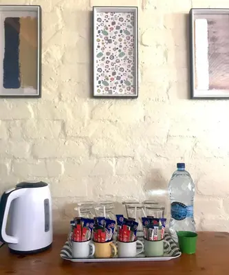 a table with cups and a bottle of water at Old Transvaal Inn Accommodation in Dullstroom