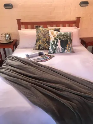 a bed with a book and a magazine on it at Old Transvaal Inn Accommodation in Dullstroom