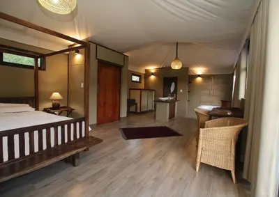 a bedroom with a bed and a table and chairs at Inzalo Safari Lodge in Welgevonden Game Reserve