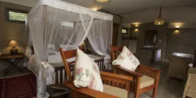 a bedroom with a canopy bed with pillows at Inzalo Safari Lodge in Welgevonden Game Reserve