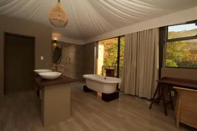 a large bathroom with two sinks and a bath tub at Inzalo Safari Lodge in Welgevonden Game Reserve