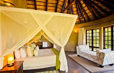 a bedroom with a bed with a mosquito net at Vuyani Safari Lodge in Hoedspruit