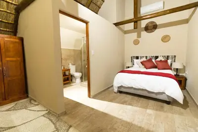 a bedroom with a bed and a large mirror at Vuyani Safari Lodge in Hoedspruit