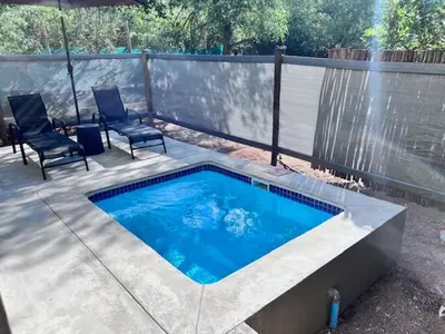 a swimming pool on a patio with two chairs at Turaco Lodge - No Loadshedding in Marloth Park