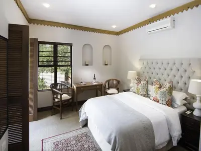 a bedroom with a large white bed and a desk at Bohemian Guesthouse - Pretoria in Pretoria