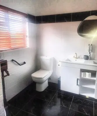 a bathroom with a white toilet and a sink at Bohemian Guesthouse - Pretoria in Pretoria