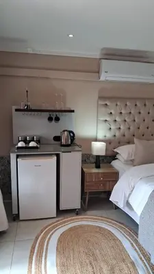 a bedroom with a bed and a kitchen in it at Bohemian Guesthouse - Pretoria in Pretoria
