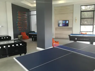 a room with a ping pong table and a tv at The Blyde - Crystal Lagoon Penthouse Apartment in Pretoria