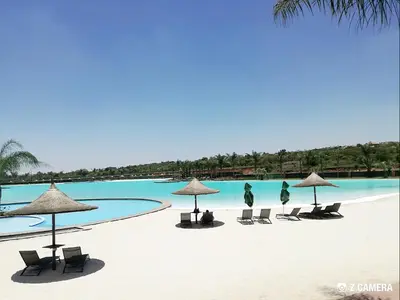 a group of chairs and umbrellas on a beach at The Blyde - Crystal Lagoon Penthouse Apartment in Pretoria